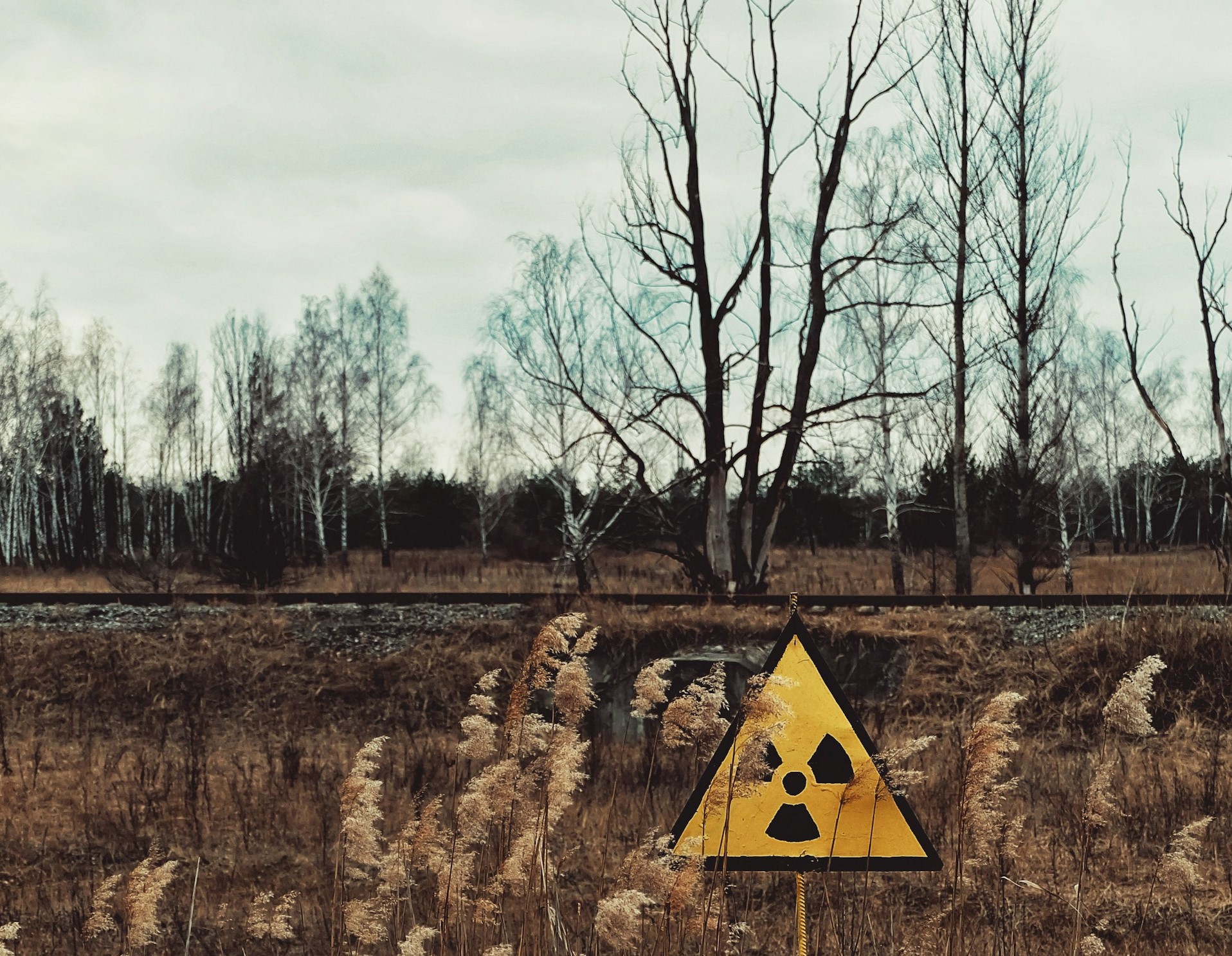 Empty, desolate landscape with a nuclear warning sign foregrounded